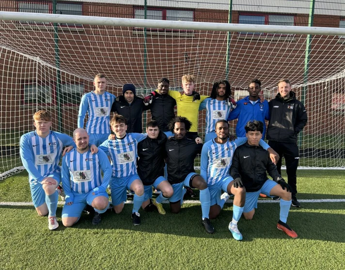 Glasgow Kelvin College men's football team posing together in front of a goal on the pitch, wearing blue and white kits. Glasgow Kelvin College men's football team posing together in front of a goal on the pitch, wearing blue and white kits.